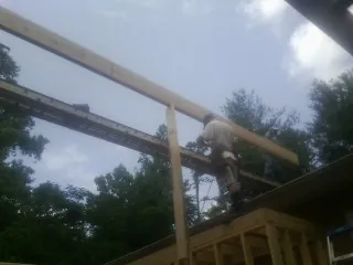 Carpenter setting a ridge beam over a new addition frame — Ice Dam Removal by Roofing Brothers in Lynwood