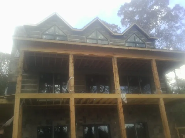 Dormers and porch framing on a large log home under construction — Roof Coating work by our crew in Lynwood