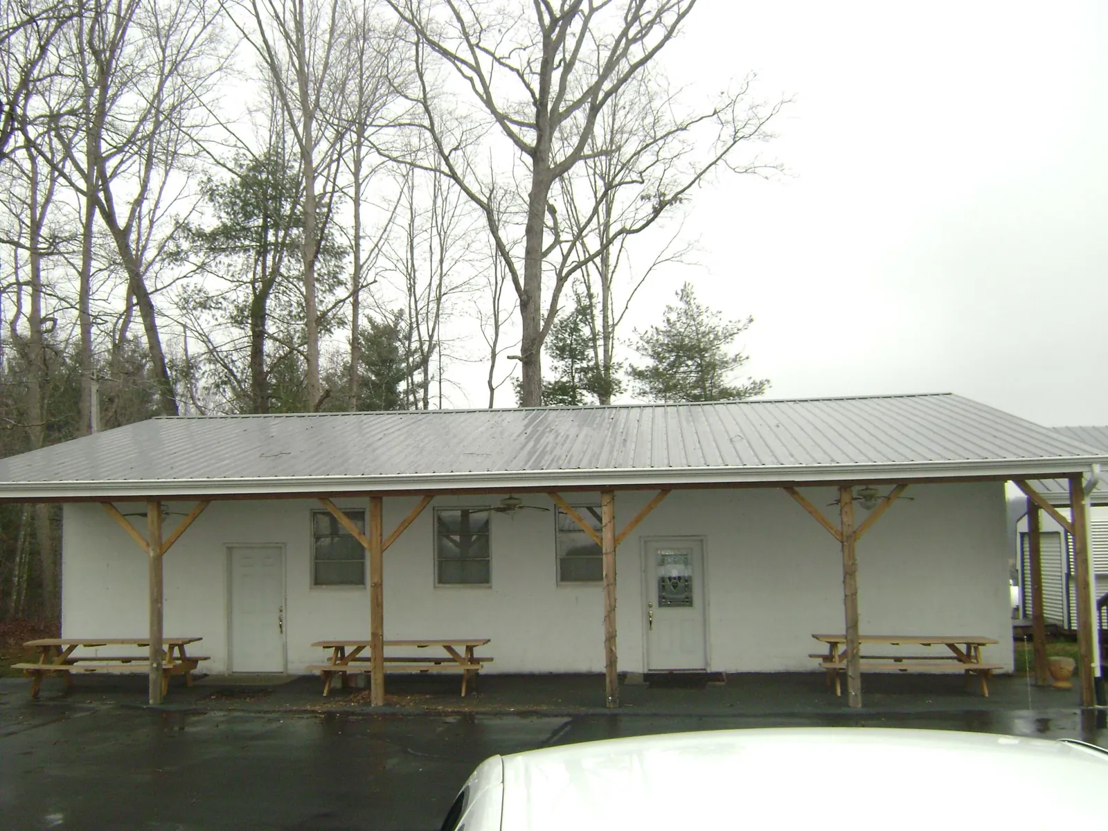 Gray metal roof over a block building with a timber post porch in Lynwood